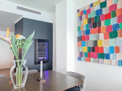 une salle à manger avec une table et une peinture colorée dans l'établissement Nestor&Jeeves - LE ROYAL LUXEMBOURG - Sea view - Terrace, à Nice