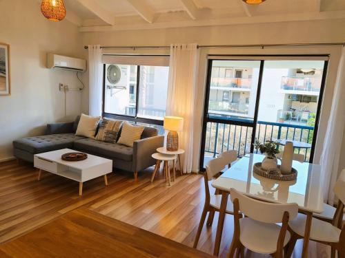 a living room with a couch and a table at Beach Break Iconic Scarborough in Perth