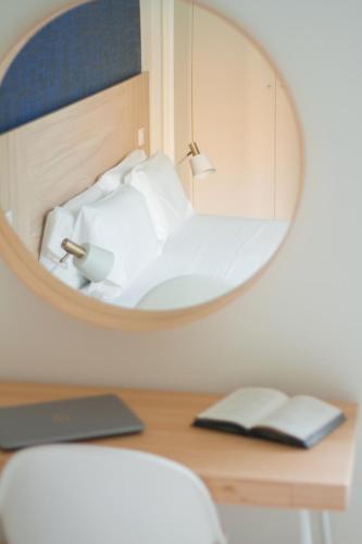 a mirror on a desk with a bed in a room at Select Porto Suites in Porto