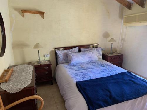 1 dormitorio con 1 cama con sábanas azules y 2 mesitas de noche en Beautiful 3-Bed Town House with garden in Sax, en Sax