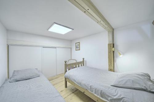 1 dormitorio con 2 camas y ventana en Loft en duplex avec balcon et vue, en Arreau