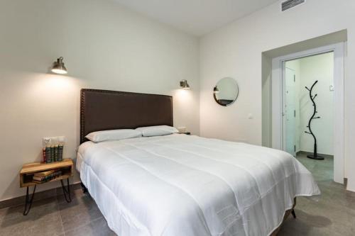 - une chambre avec un grand lit blanc et une grande couverture blanche dans l'établissement Estrena Apartamento en centro historico de Almeria, à Almería