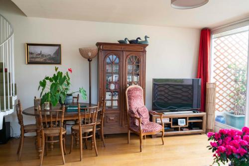 une salle à manger avec une table et une télévision dans l'établissement Charming duplex with two balconies in the 13th, à Paris