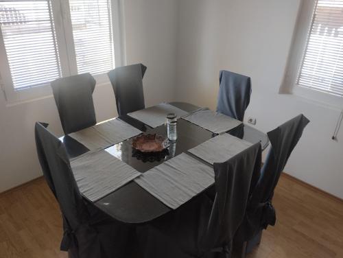 uma mesa de jantar com cadeiras e uma toalha de mesa preta em Kuća za odmor Jezero em Ostrovo