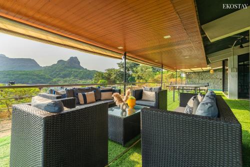 an outdoor living room with couches and a view of mountains at EKO STAY - Sky Villa in Lonavala