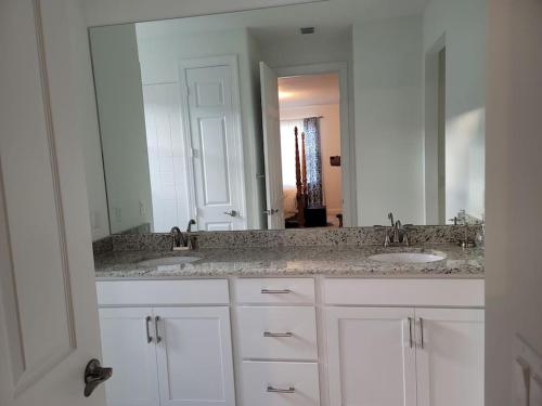 baño con 2 lavabos y espejo grande en Home sweet home, en Port Saint Lucie