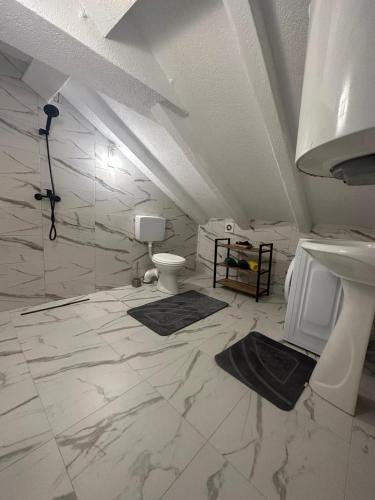 a white bathroom with a sink and a toilet at Apartman Sun house Kumbor 2 in Herceg-Novi