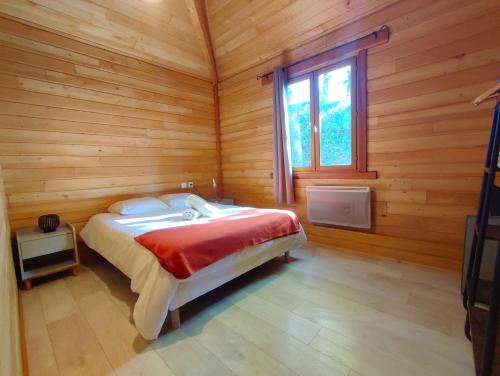 sypialnia z łóżkiem w drewnianym domku w obiekcie Le Chalet w mieście Malause