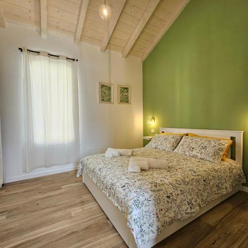 a bedroom with a bed and a green wall at Casetta Meravigliosa Paullo in Paullo