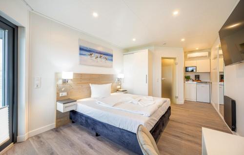 Un dormitorio con una cama grande y una cocina. en Apartments Waterfront, en Sagard