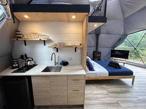 a kitchen with a sink and a bed in a tent at Aurora in Saint Come