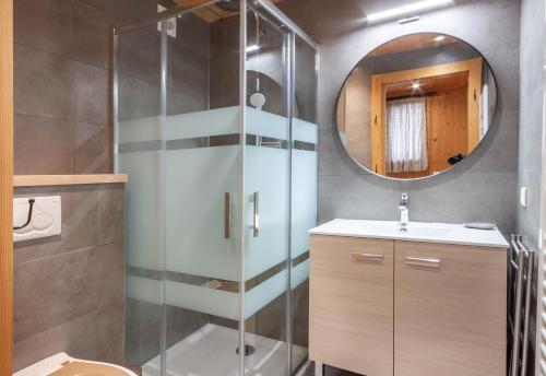 a bathroom with a shower and a sink and a mirror at Gd Hotel in Morzine