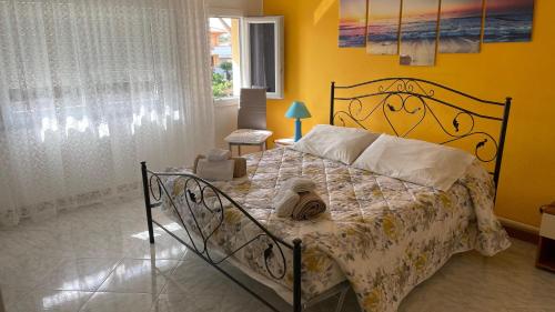 a bedroom with a bed with a yellow wall at Casa vacanze da Roberta a pochi km da Oristano in Simaxis