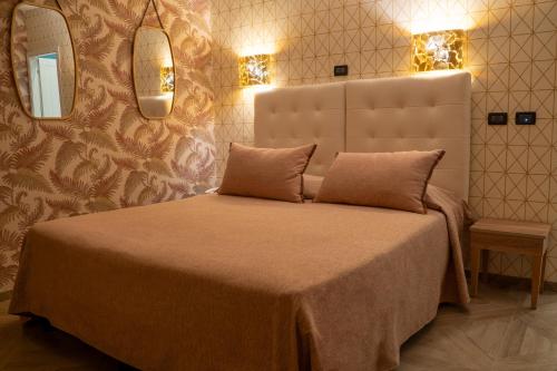 a bedroom with a bed with two mirrors on the wall at Hotel Il Guercino in Bologna