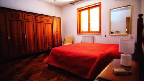 a bedroom with a red bed and a mirror at Aloha Village - Bed&Pet in Messina
