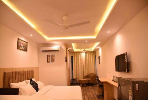 a hotel room with a bed and a ceiling fan at The Grand hotel and suites studio M Leo in Jaipur
