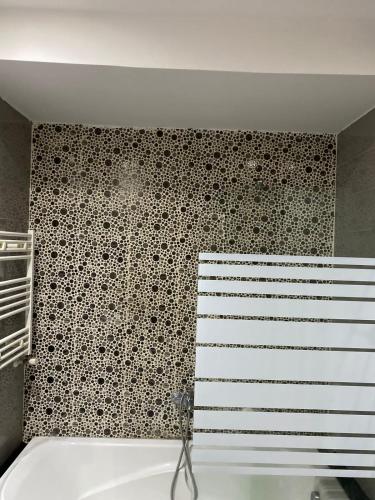 a bathroom with a black and white tiled wall at Résidence palmerie 1 in La Marsa