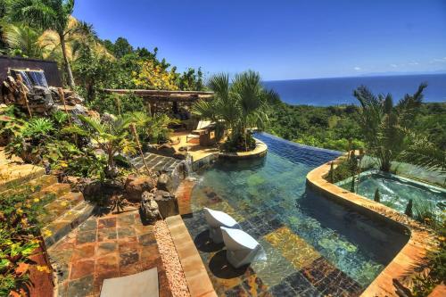 an infinity pool with a view of the ocean at Casa El Paraiso, Eco Lodge in Santa Bárbara de Samaná