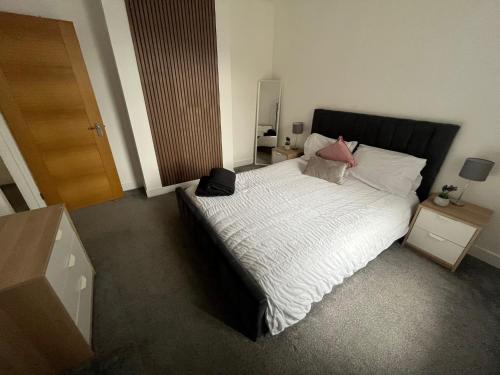 Jefferson Avenue Apartment في بورنموث: غرفة نوم بسرير كبير مع شراشف بيضاء ومخدات وردية