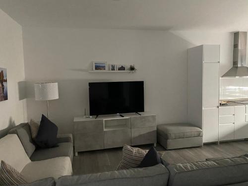 uma sala de estar com uma televisão de ecrã plano e um sofá em Casa Bagacera "Cera" em Ingenio