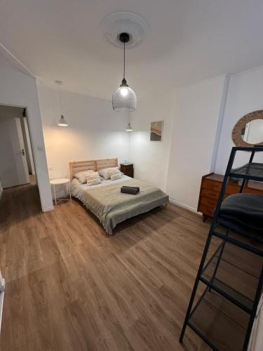 een slaapkamer met een bed en een houten vloer bij Le Decazes, Séjournez à deux pas de la plage in Marseille