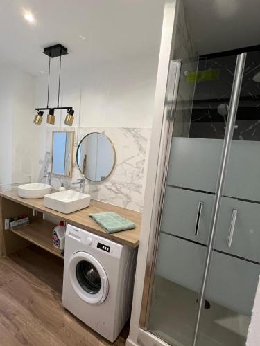 une salle de bain avec une machine à laver et un lavabo dans l'établissement Le Decazes, Séjournez à deux pas de la plage, à Marseille