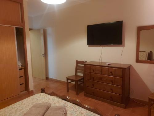 a bedroom with a dresser with a television on the wall at Angela Beach Place in Vila Baleira