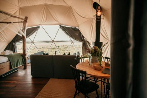 Pokój z namiotem ze stołem i łóżkiem w obiekcie Dome Meadow 1 with Log Burning Tub At Tapnell Farm w mieście Yarmouth
