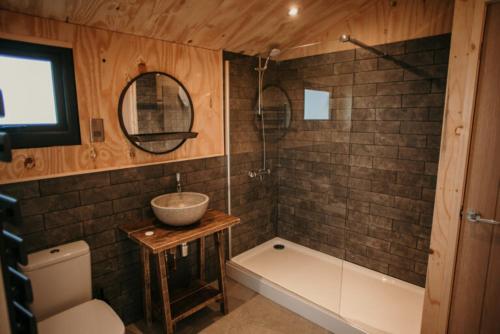 a bathroom with a sink and a bath tub and a sink at Dome Meadow 1 with Outdoor Tub At Tapnell Farm in Yarmouth