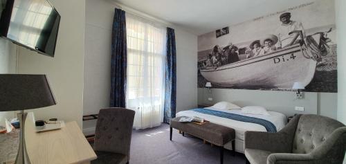 a bedroom with a bed and a picture of a boat on the wall at Hôtel Windsor Contact Hôtel in Dieppe