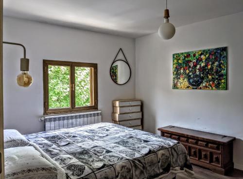 a bedroom with a bed and a painting on the wall at Casa Micisca - Pescasseroli Centro in Pescasseroli
