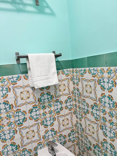 La salle de bains est pourvue d'un lavabo et d'une serviette murale. dans l'établissement Calliope Sorrento Apartment, à Sorrente