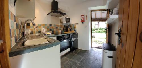 a small kitchen with a sink and a stove at Haywains Self-Catering at Boningale Manor in Wolverhampton