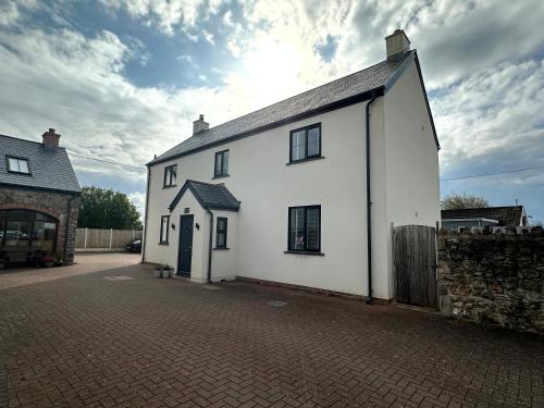 a white building on a brick street at Whitebridge Cottage in Swansea