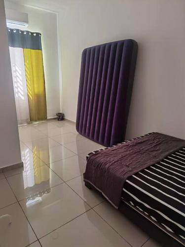 a bedroom with a bed sitting on a tiled floor at Homestay Medina Sendayan in Kampong Baharu Jimah