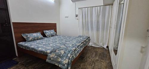 um pequeno quarto com uma cama e uma janela em HOMESTAY - AC 3 BHK NEAR AlRPORT em Chennai