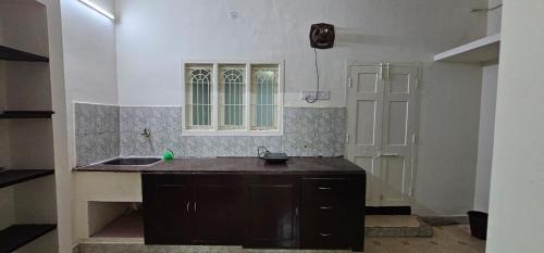 uma cozinha com um lavatório e uma janela em HOMESTAY - AC 3 BHK NEAR AlRPORT em Chennai