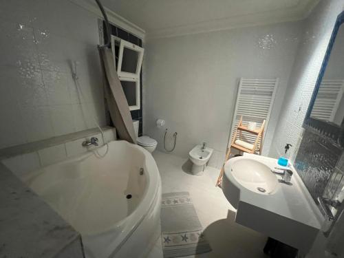 a white bathroom with a toilet and a sink at appartement 14 in Chott Meriem
