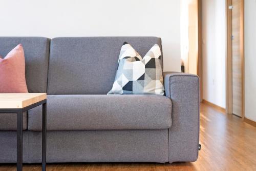 a gray couch with a pillow on it in a living room at Ebnerhof in Collalbo