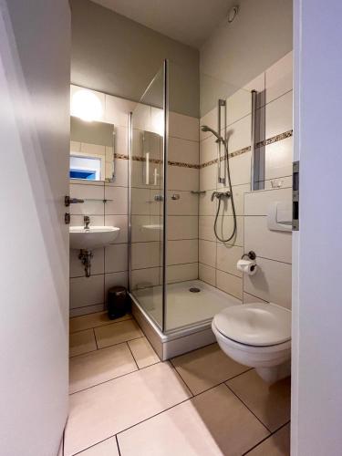 a bathroom with a shower and a toilet and a sink at Studios am Hafen in Stralsund