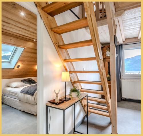 escalera en un dormitorio con cama y ventanas en Chez Marie T3 Vuiz, en Viuz-en-Sallaz