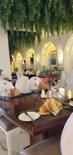 a dining room with a wooden table and white chairs at The Palms Hotel in Abuja