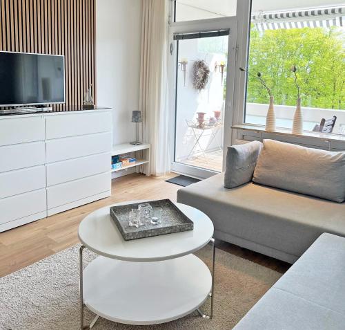 un soggiorno con divano, tavolo e TV di Driftberg 1 Whg 18 a Grömitz