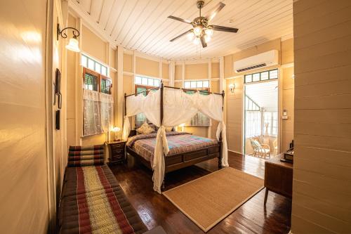 a bedroom with a bed and a ceiling fan at Wallaya Heritage Stay in Bangkok
