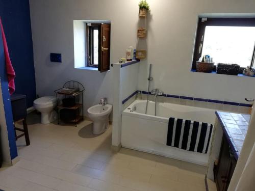 ein Badezimmer mit einer Badewanne, einem WC und einem Waschbecken in der Unterkunft Scacciapensieri's home in Trecastagni