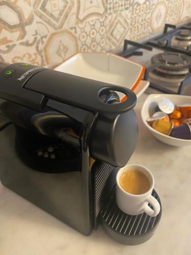 een koffiezetapparaat met een kopje koffie op een aanrecht bij Il Terrazzo di Ale in Licola