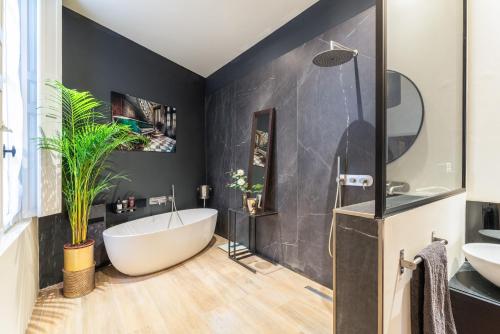 une salle de bain avec une baignoire blanche et un lavabo dans l'établissement centre historique Avignon appartement Haussmannien 140 m2, à Avignon