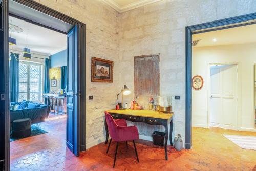 Cette chambre dispose d'un bureau et d'une chaise rouge. dans l'établissement centre historique Avignon appartement Haussmannien 140 m2, à Avignon