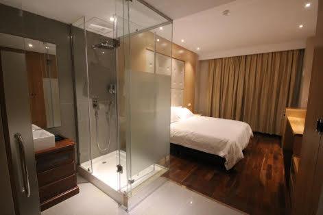 a bedroom with a glass shower and a bed at Menoir Dorsett Madrid Leganés in Leganés