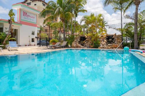 a large swimming pool at a hotel with palm trees at Monaco Vacation Rentals in Clearwater Beach